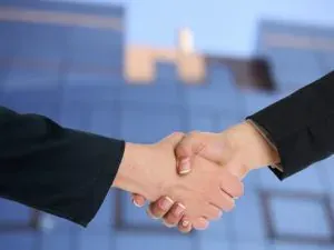 Business handshake before glass building