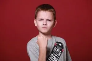 Boy with fist on red background