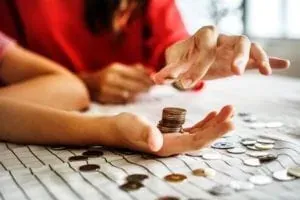 Hands counting coins on table