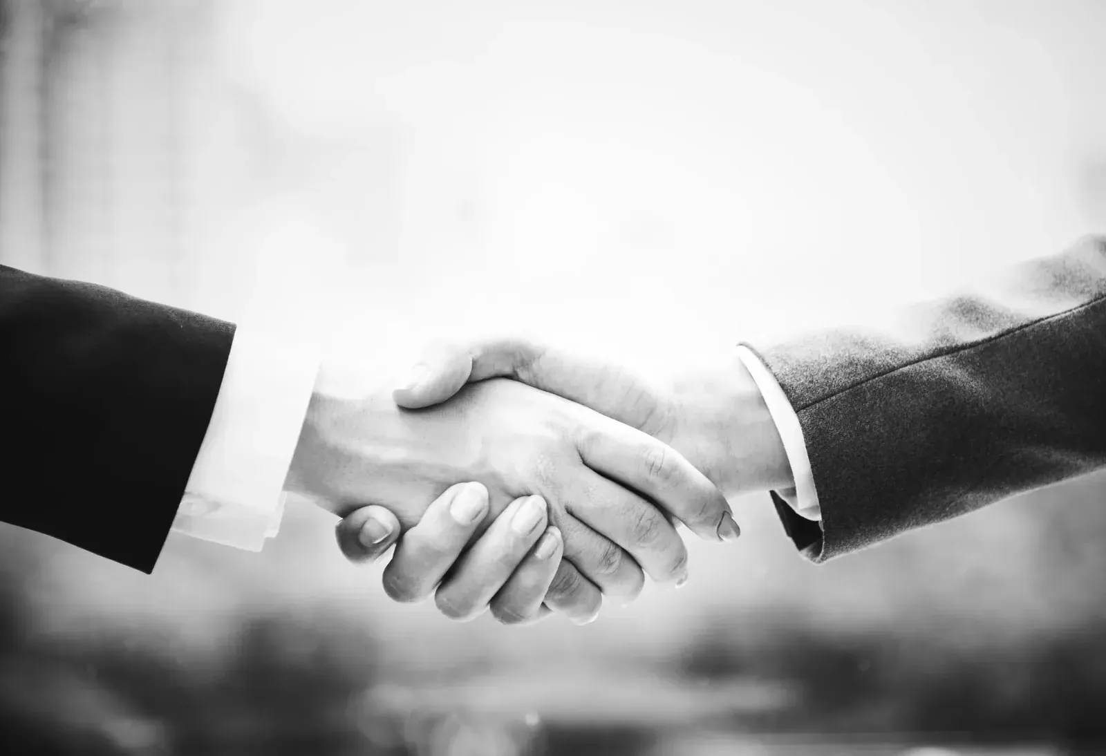Black-and-white handshake between two people in suits