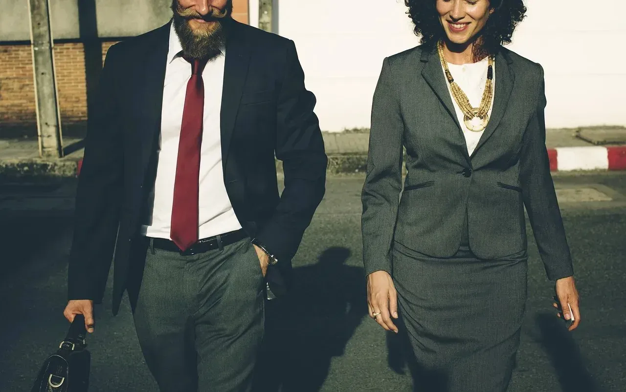 Bearded man and woman in business attire walking outside