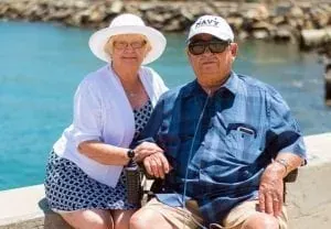 Elderly couple seated by the sea