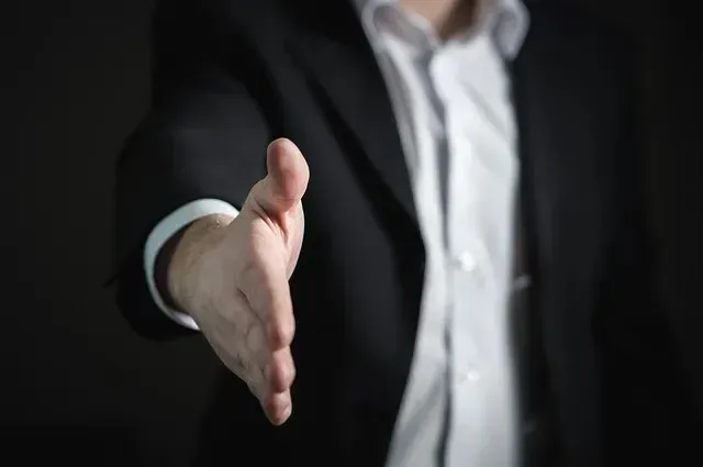 Man in suit extending hand for handshake