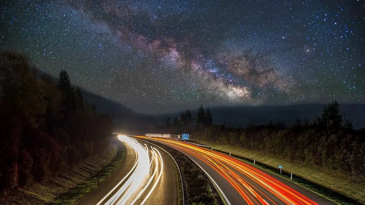 Milky Way over highway with car light trails