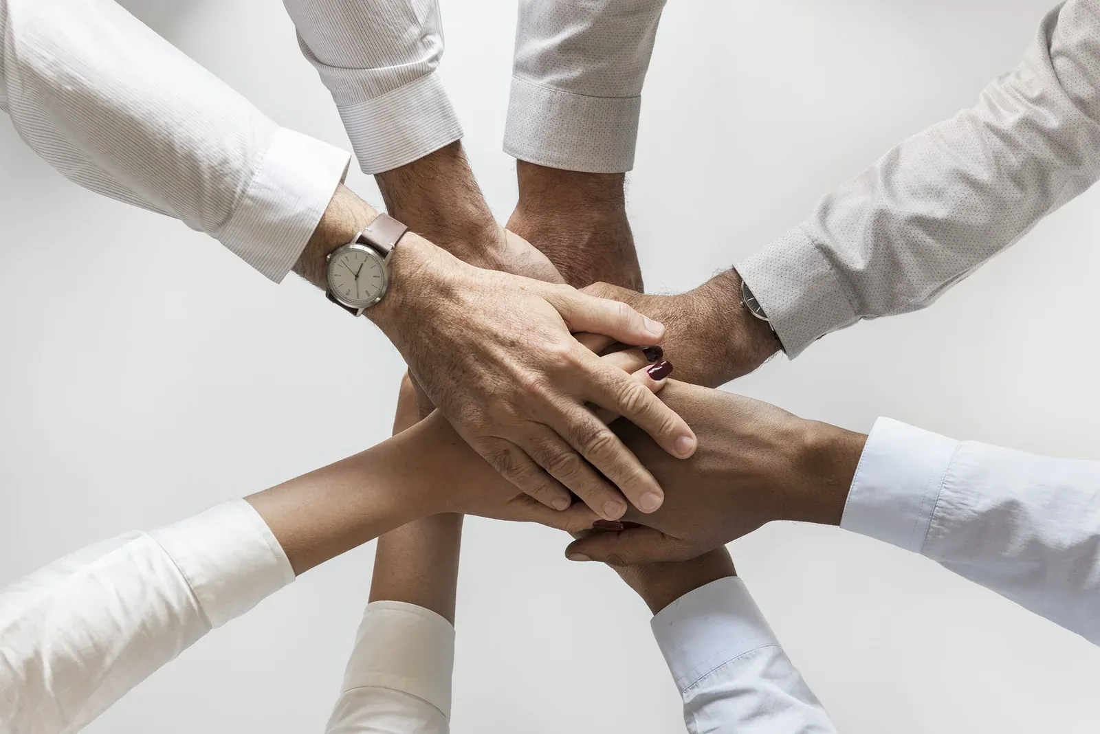 Diverse business team stacking hands together, overhead view