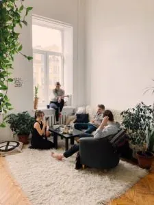 Friends relaxing in plant-filled living room