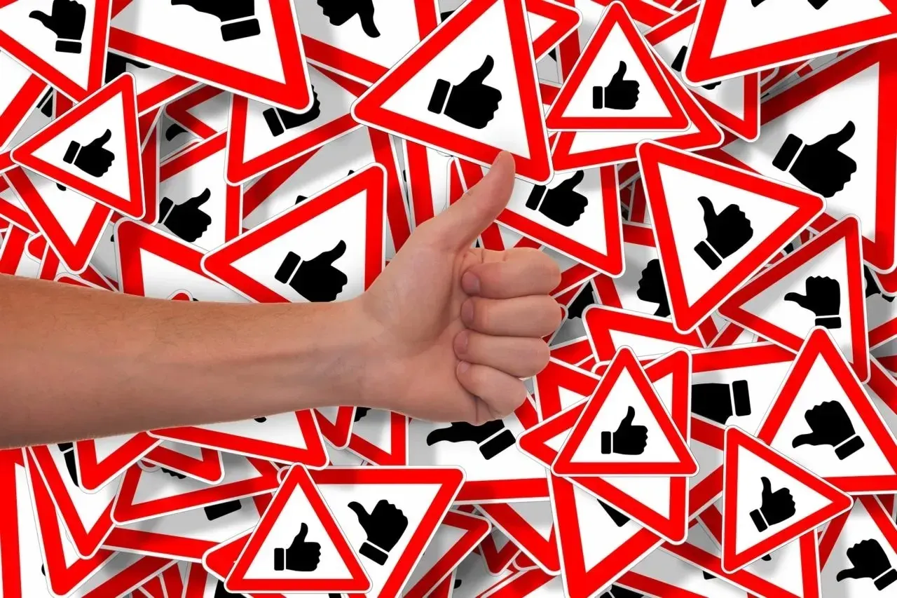 Thumbs-up hand among red triangular thumbs-up signs