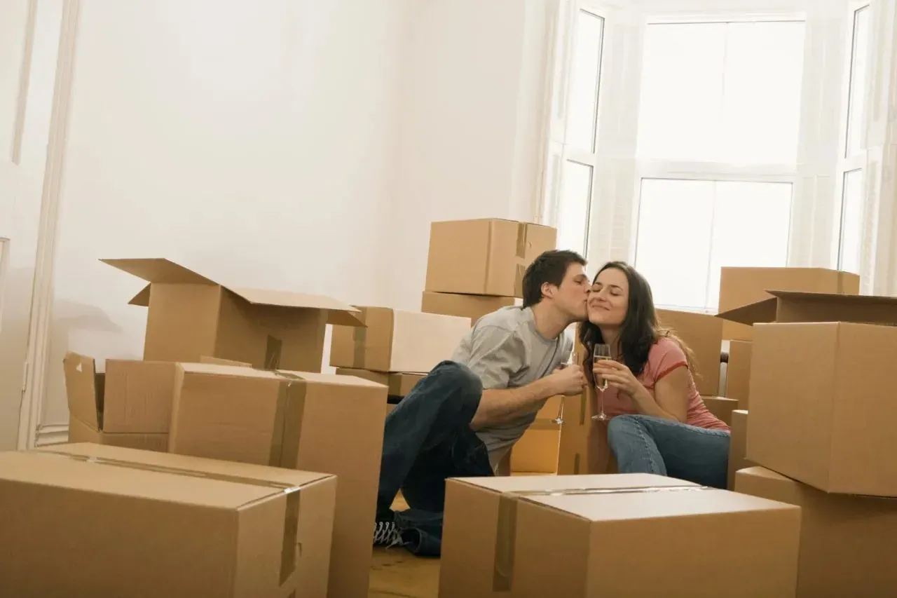 Couple celebrating with champagne among moving boxes