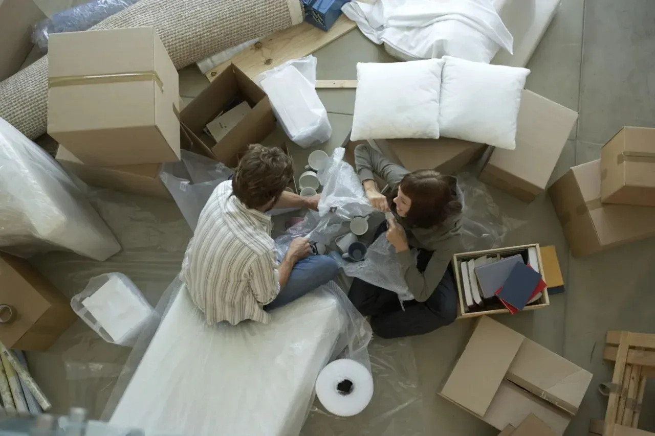 Overhead view of couple unpacking boxes and bubble wrap