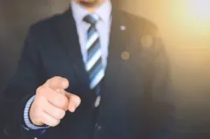 Suited man pointing at camera
