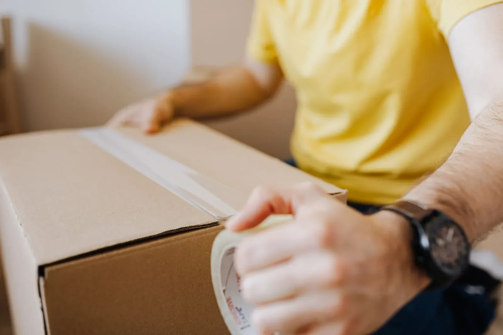 Woman holding box, yellow background