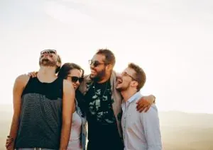 Four friends laughing outdoors
