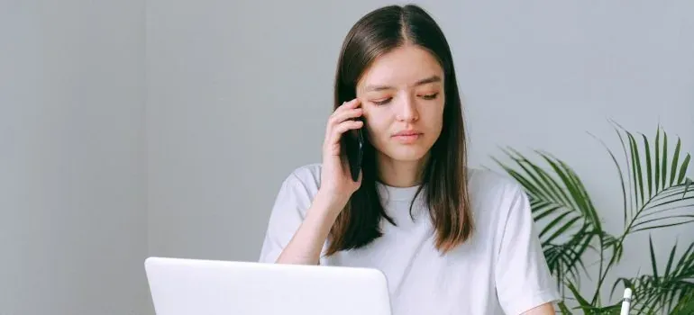 Woman on phone with laptop
