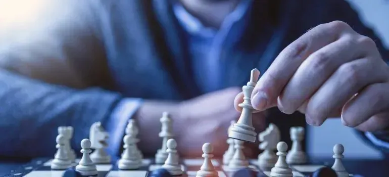 Close-up of man moving chess piece on board