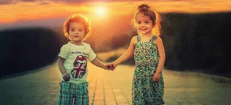 Two children holding hands at sunset