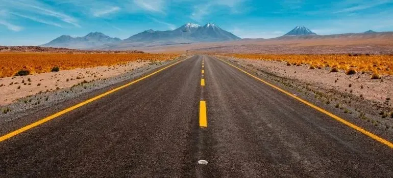 Straight desert highway leading toward distant mountains