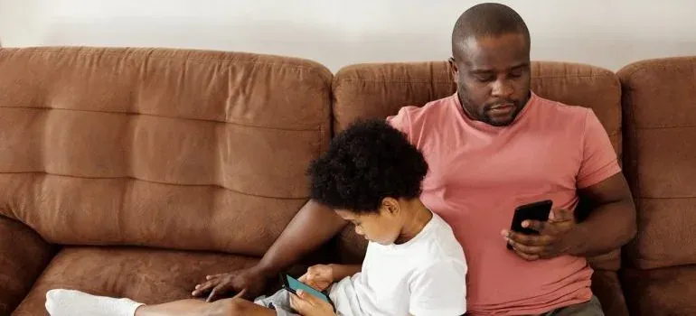 Father and son on sofa with phones