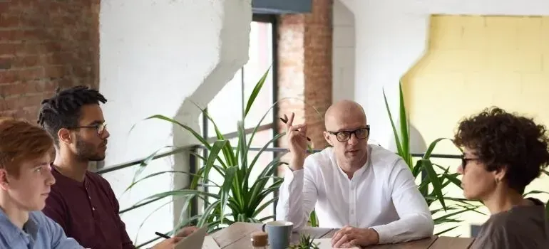 Team meeting around table in plant-filled loft office