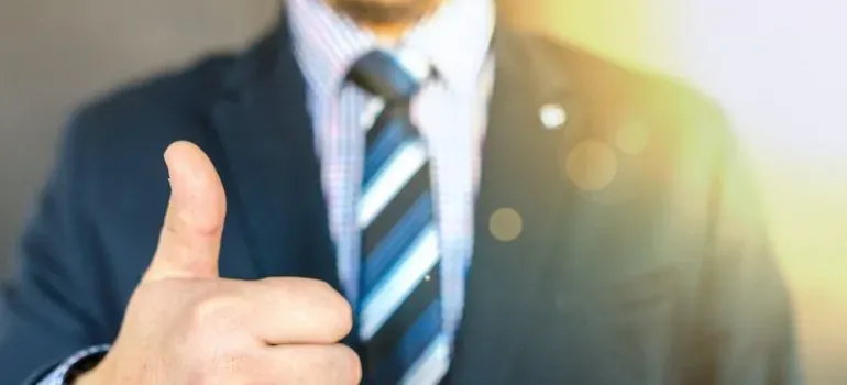 Businessman in suit giving thumbs up