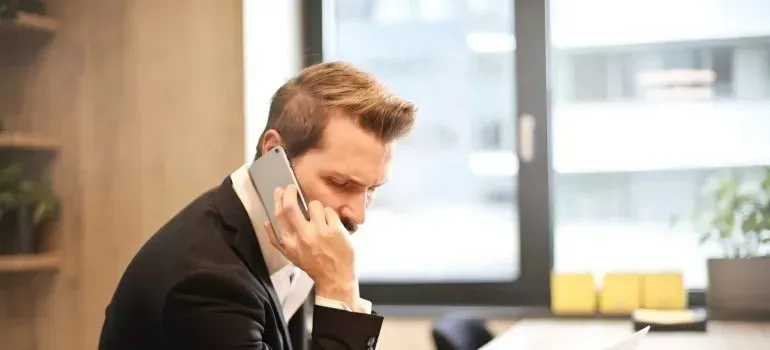 Businessman in suit making phone call at office
