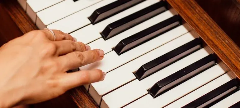 Hand playing piano keys close-up
