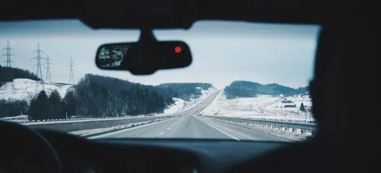 Snowy highway viewed through a car windshield