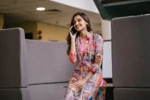 Smiling woman on phone indoors