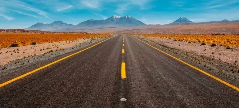 Empty desert highway leading toward distant mountains