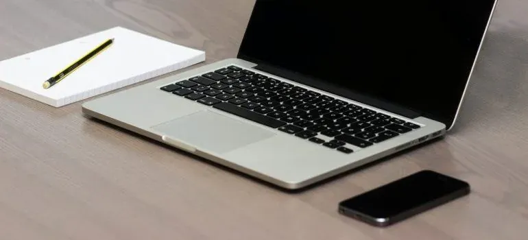 Laptop, notepad, phone on desk