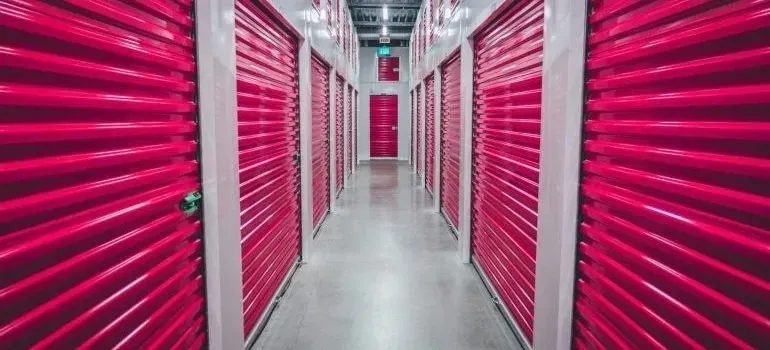 Storage facility hallway lined with pink roller doors