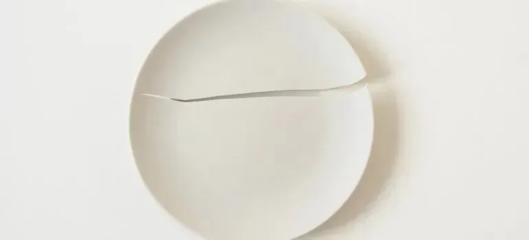 Cracked white ceramic plate on white background