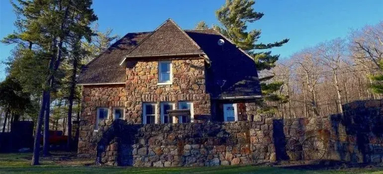 Rustic stone house with stone wall among trees
