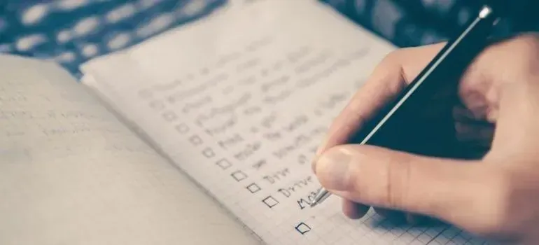 Hand writing a checklist in a grid notebook