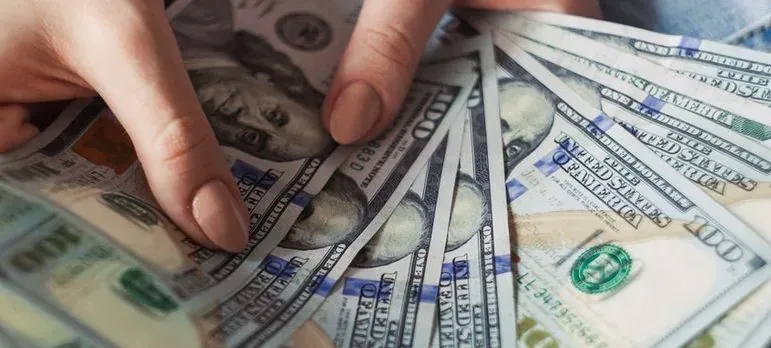 Hands fanning hundred dollar bills