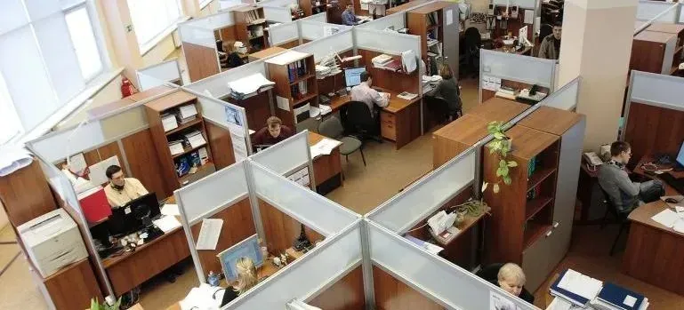 Open-plan office with cubicles and employees working