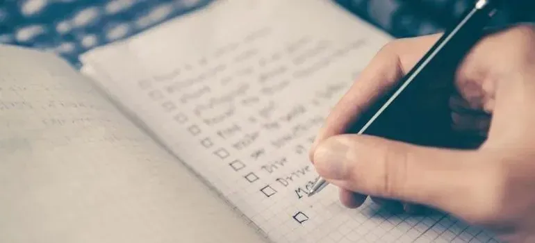 Hand checking off a handwritten checklist with a pen