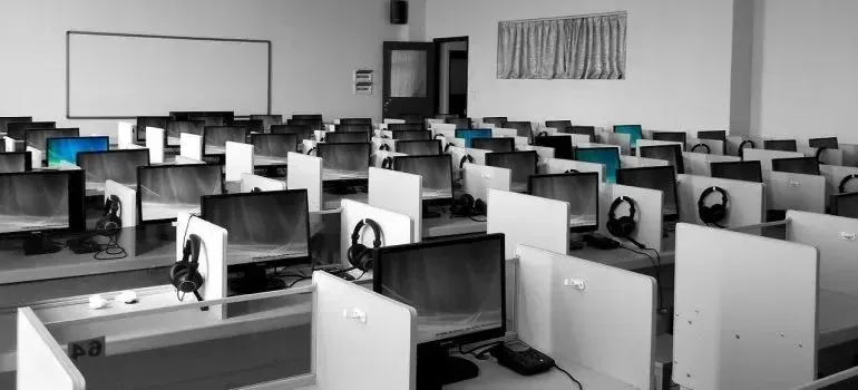 Rows of computer workstations with headsets in training room