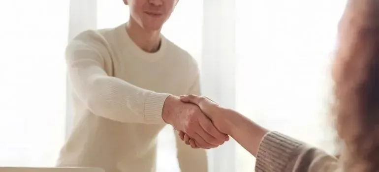 Two people shaking hands in a bright office