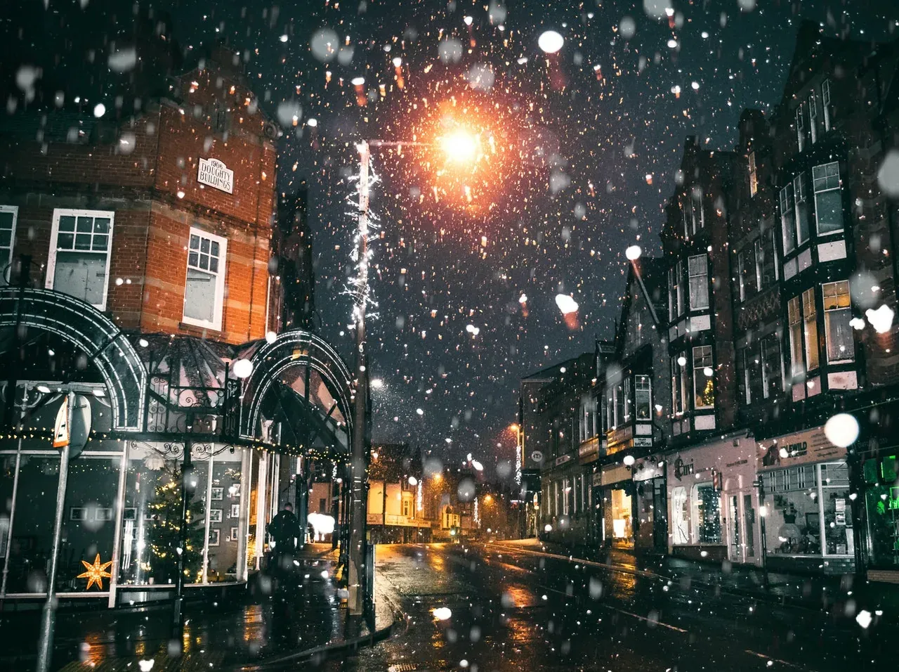 Snowy town street at night, generic shops