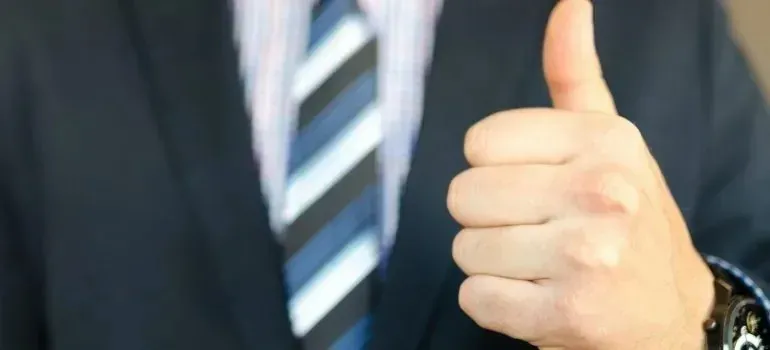 Businessman in suit and tie giving thumbs up
