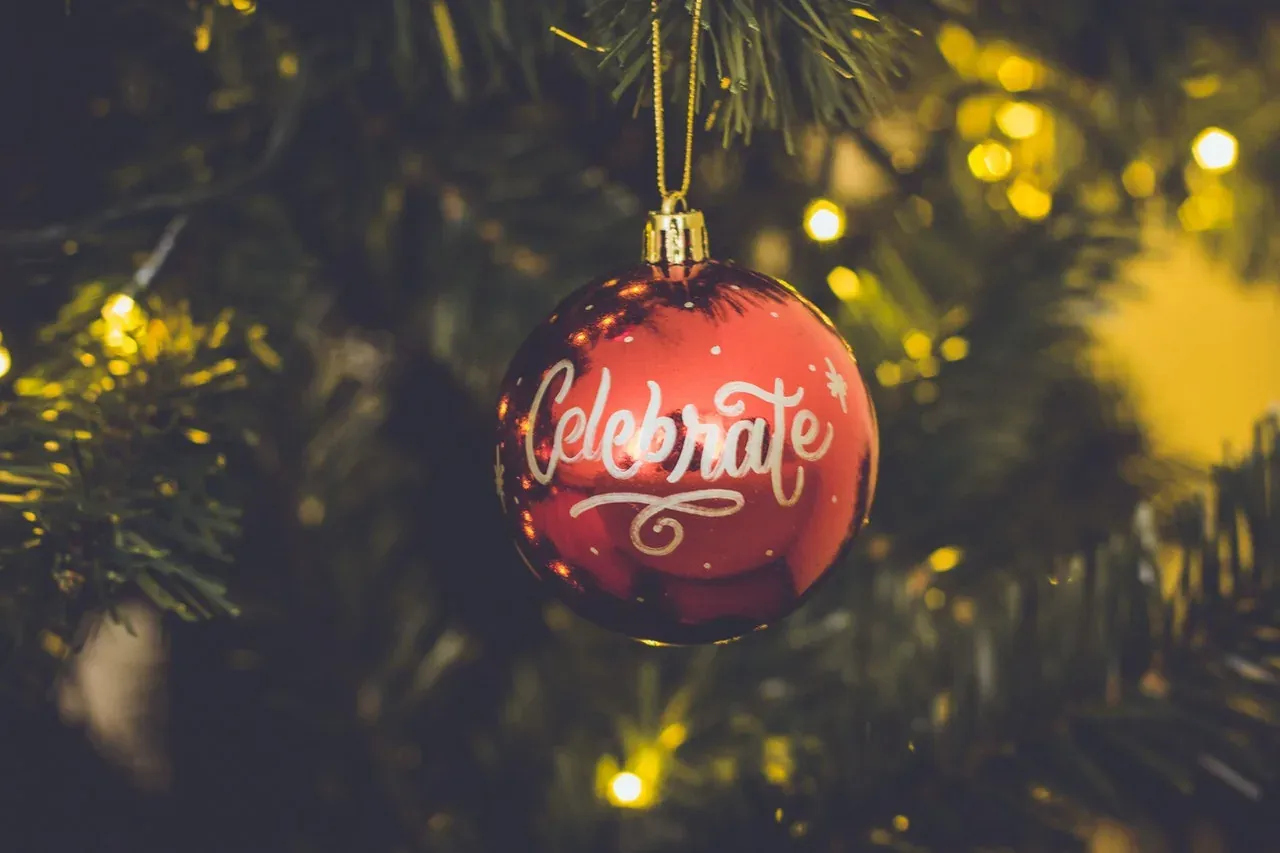 Red Celebrate ornament on Christmas tree
