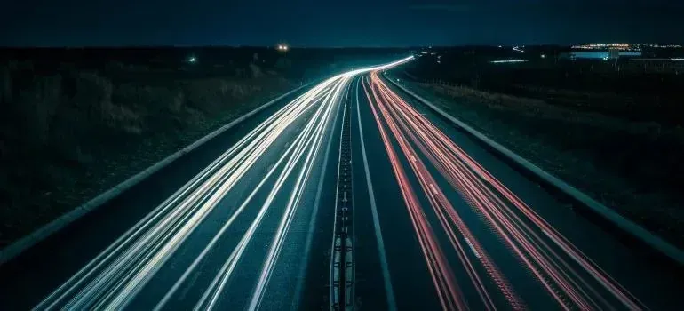 Night highway with long-exposure car light trails