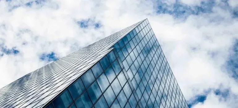Glass skyscraper corner against cloudy blue sky
