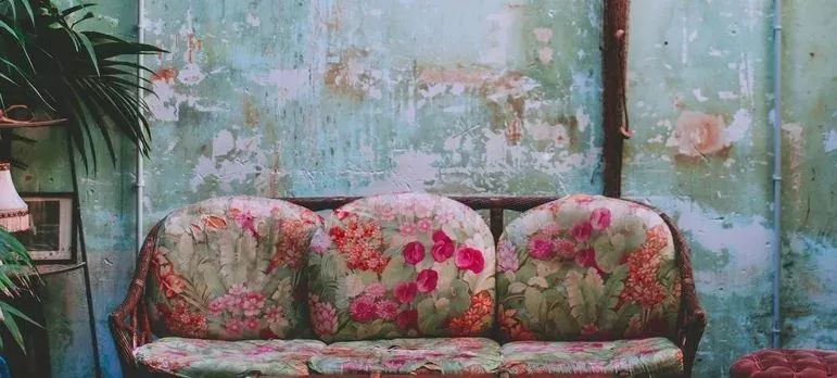 Floral vintage sofa against distressed wall