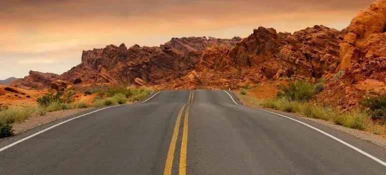Empty highway curving through red rock desert landscape