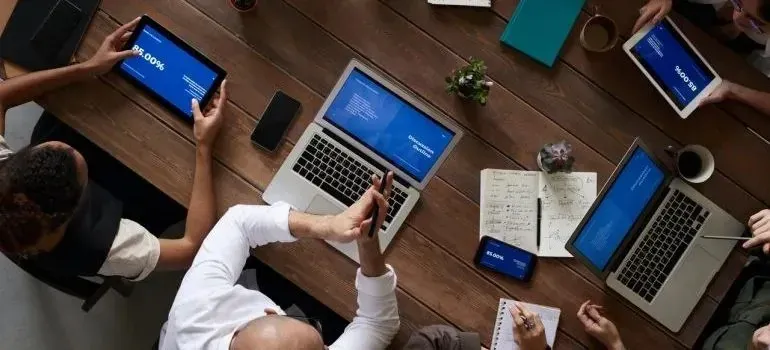 Overhead view of team meeting with laptops and tablets