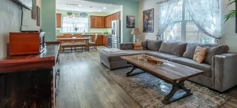 Spacious living room with gray sectional and kitchen