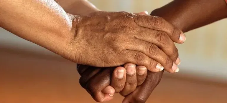 Two people clasping hands in supportive handshake