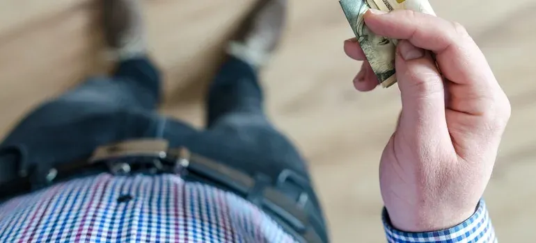 Man holding folded cash, top view