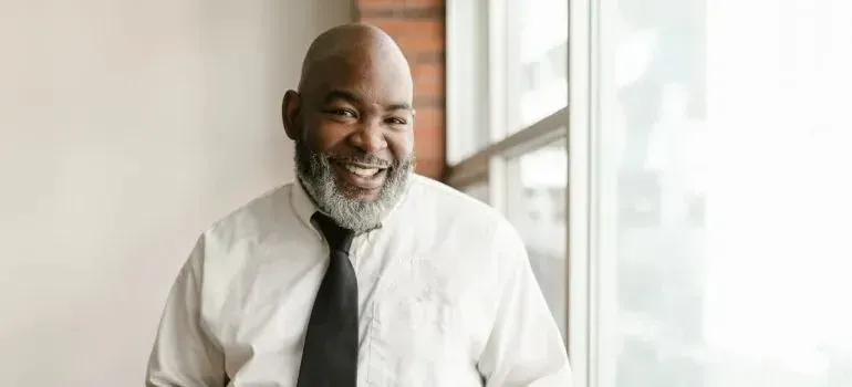 Smiling bearded man in white shirt and black tie